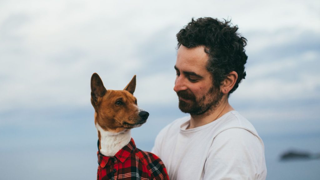 Man holding his dog, demonstrating which dog breed is most loyal.